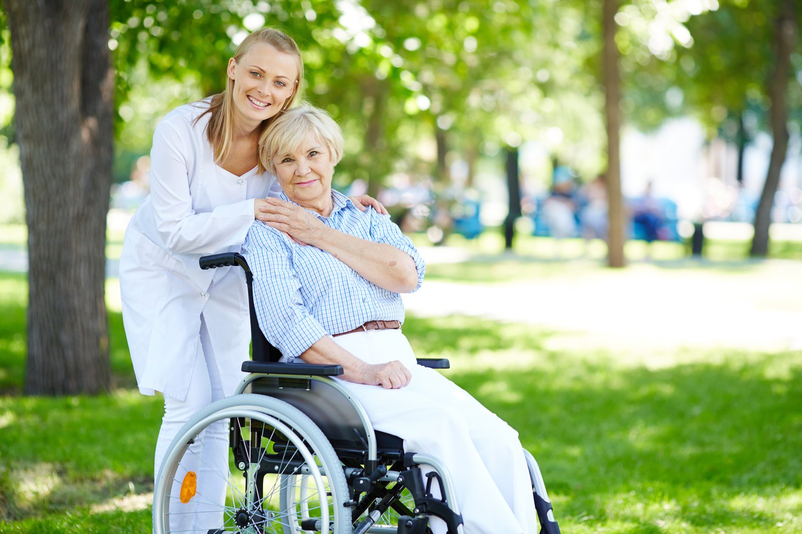 A caregiver walking outdoors with a senior woman